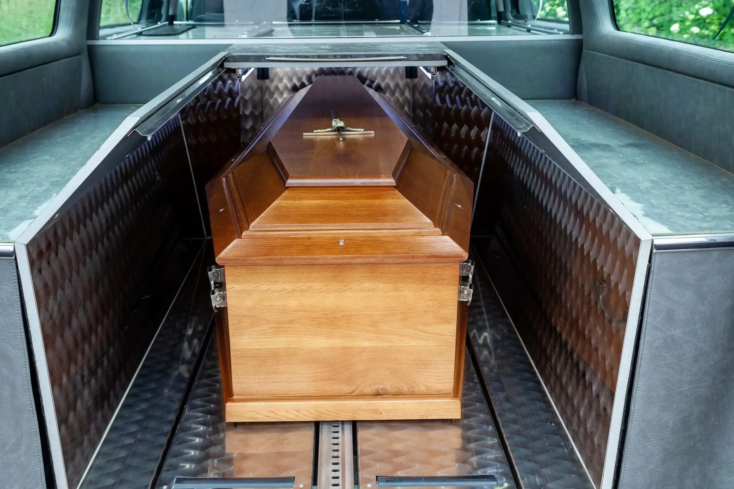 Cercueil en bois disposé à l'intérieur d'un corbillard