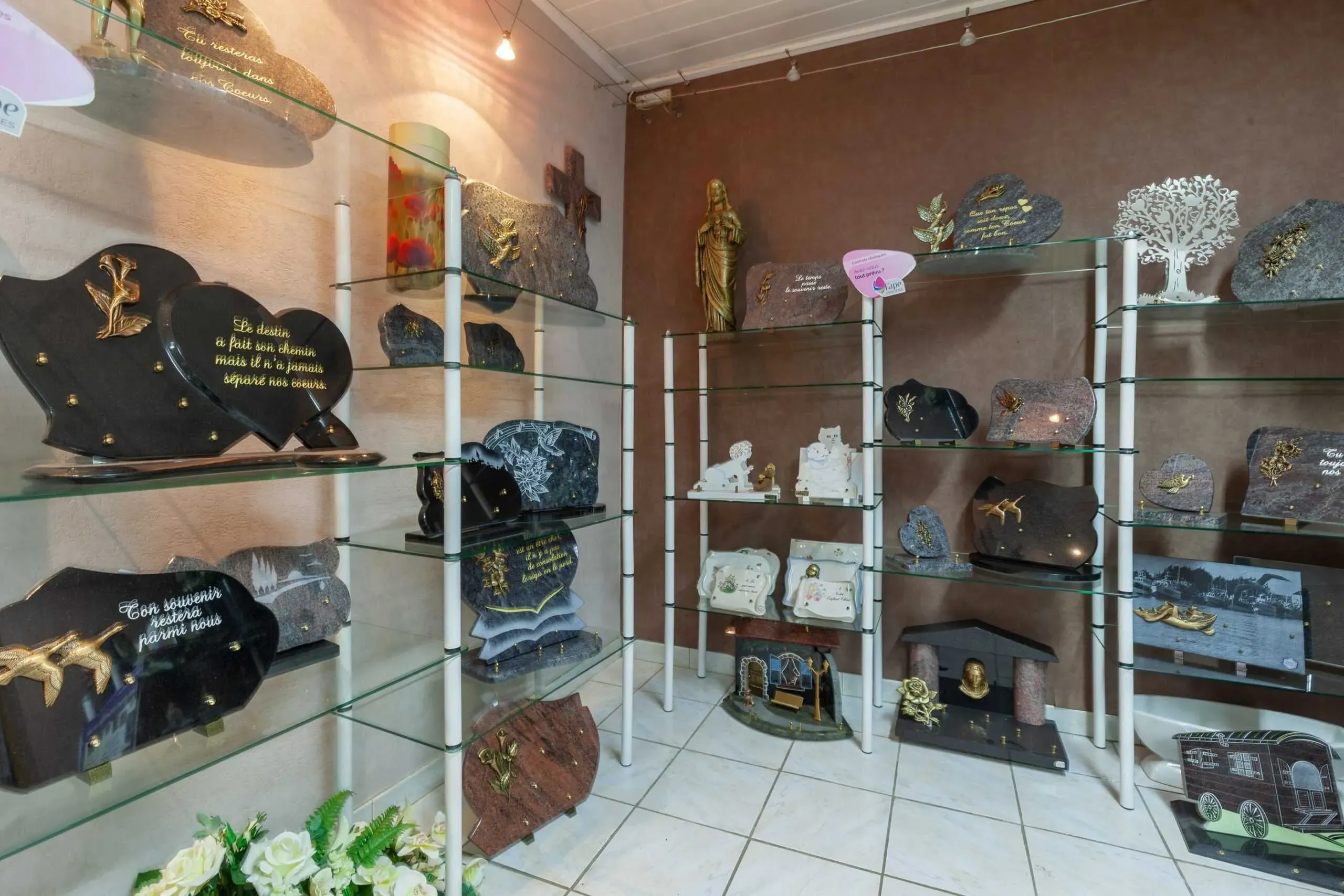 Salle d'exposition présentant diverses plaques funéraires gravées sur étagères