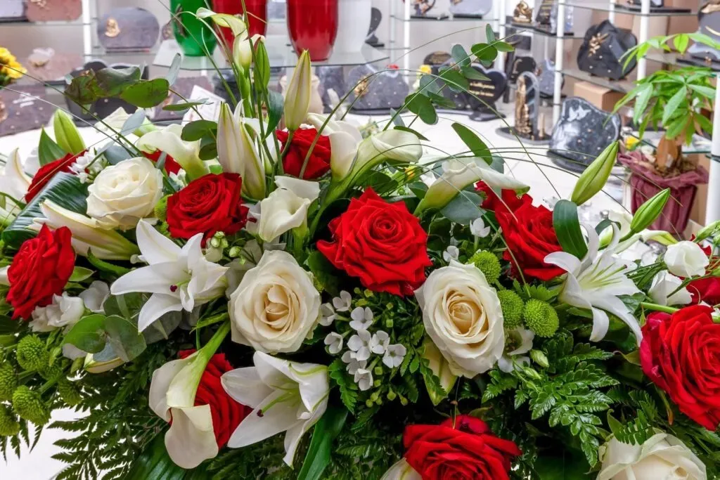 Composition florale funéraire de roses rouges, blanches et lys
